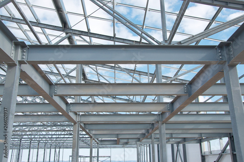 Metal frame of the new building against the blue sky with clouds