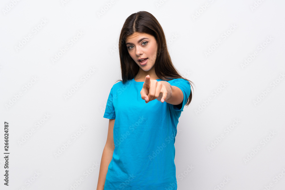 Teenager girl with blue shirt surprised and pointing front Teenager girl with blue shirt surprised and pointing front