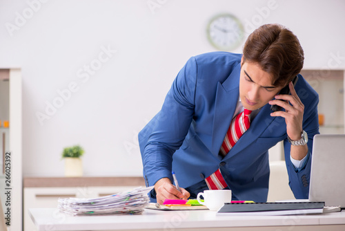 Young attractive businessman working in the office 