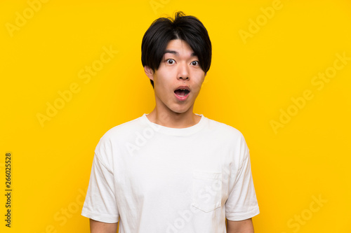 Asian man over isolated yellow wall with surprise facial expression © luismolinero
