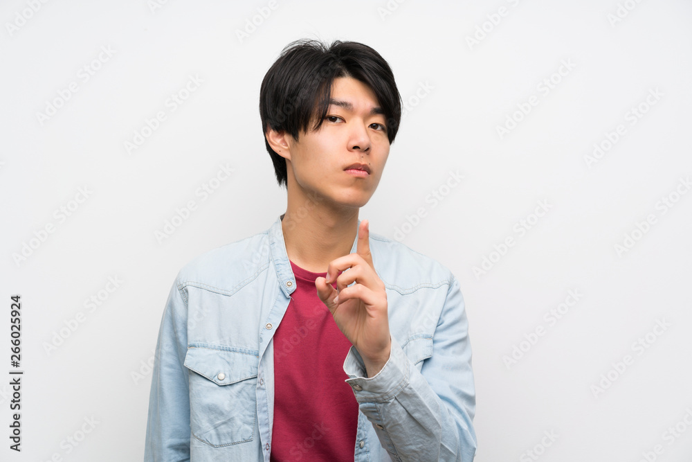 Asian man on isolated white background frustrated and pointing to the front Asian man on isolated white background frustrated and pointing to the front