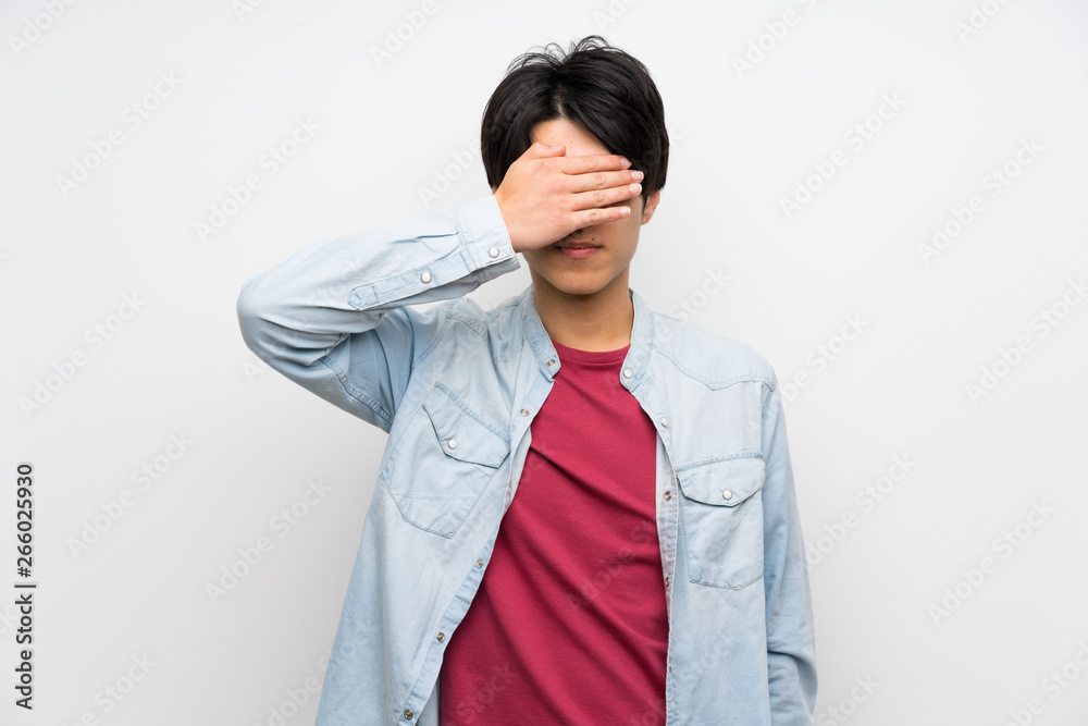 Asian man on isolated white background covering eyes by hands. Do not want to see something
