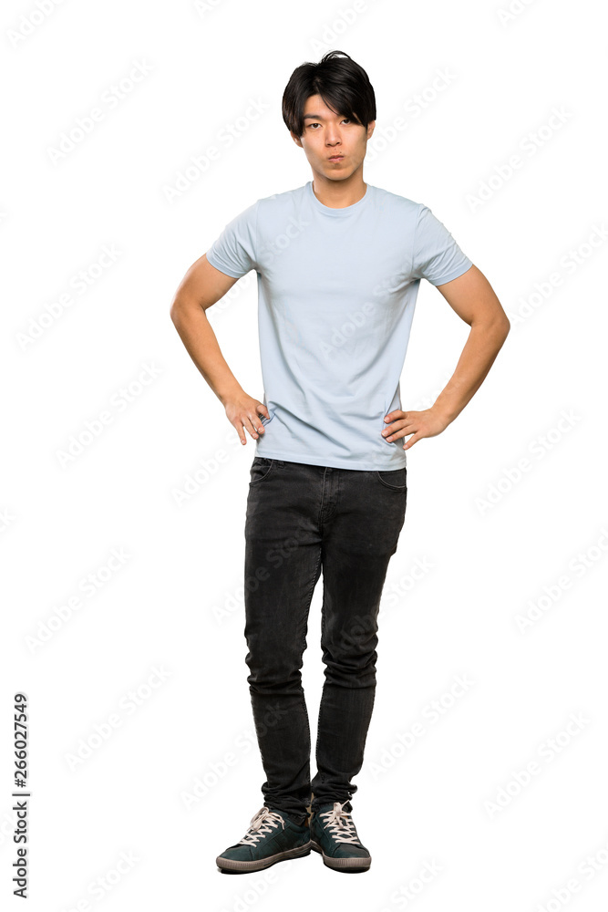 A full-length shot of a Asian man with blue shirt angry over isolated white background A full-length shot of a Asian man with blue shirt angry over isolated white background