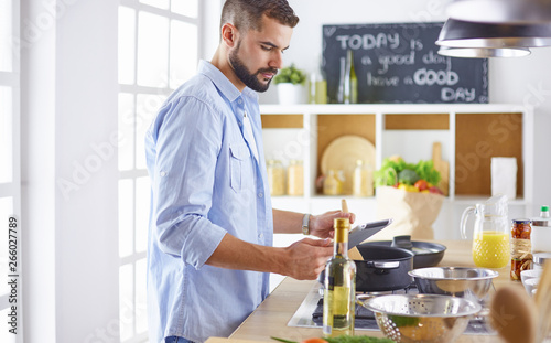 Smiling and confident chef standing in large kitchen