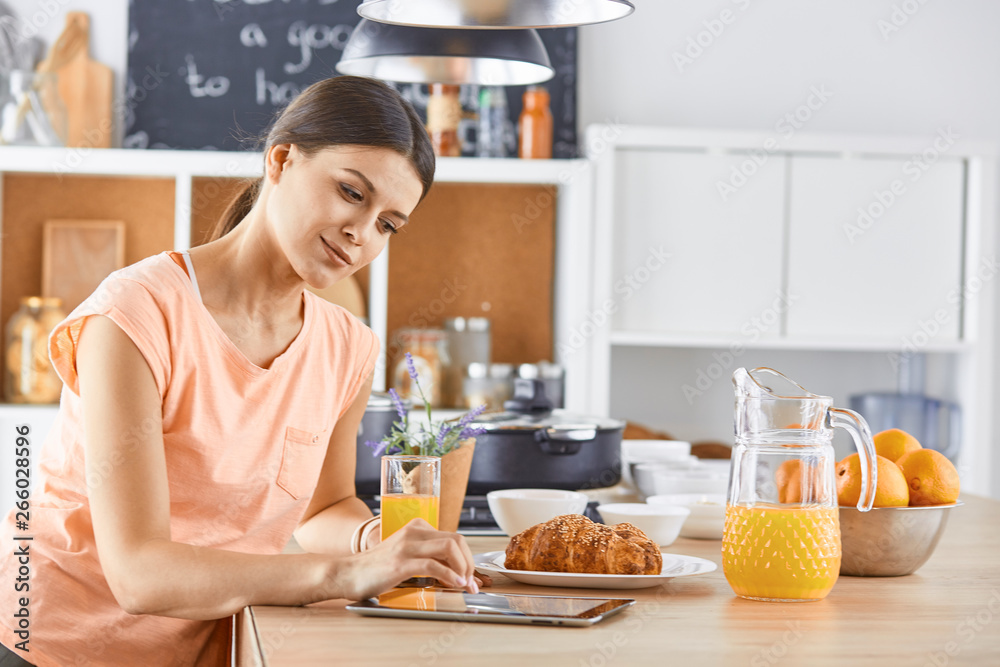 Smiling pretty woman looking at mobile phone and holding glass 