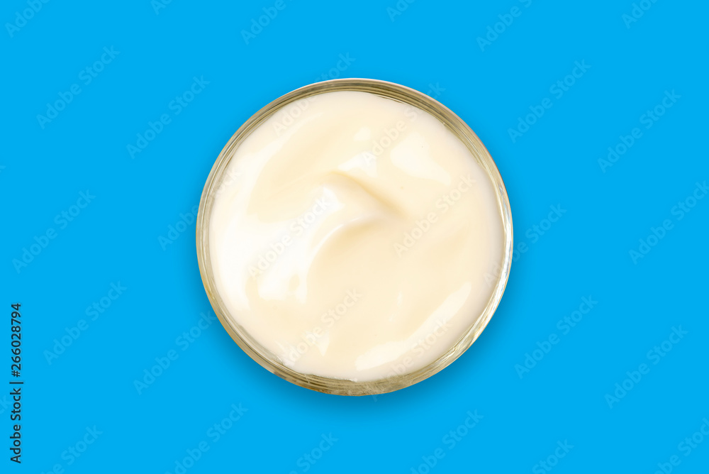 Spa cream in a glass cup placed on a blue background. Cosmetic cream camomile. Organic cosmetics with coconut on blue background top view. Spa cream in a glass cup placed on a blue background. Cosmetic cream camomile. Organic cosmetics with coconut on blue background top view.