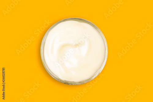 Spa cream in a glass cup placed on a Yellow background. Cosmetic cream camomile. Organic cosmetics with coconut on Isolated Yellow background top view.