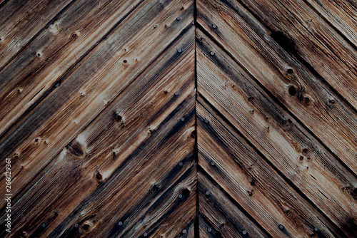 Rustic dark antique stained wood wall with aged  cracked wooden planks and nails in the countryside - vintage surface background with copyspace