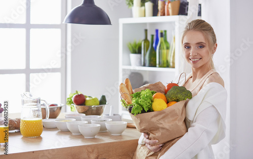 Young woman holding grocery shopping bag with vegetables Standi