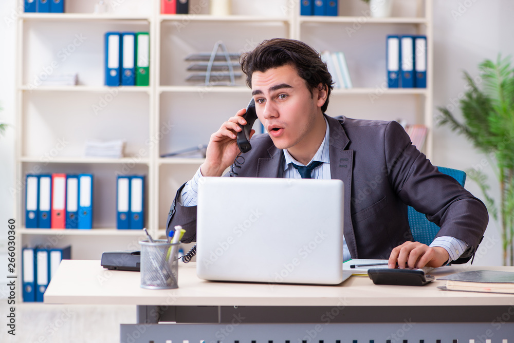 Young male employee working in the office Young male employee working in the office