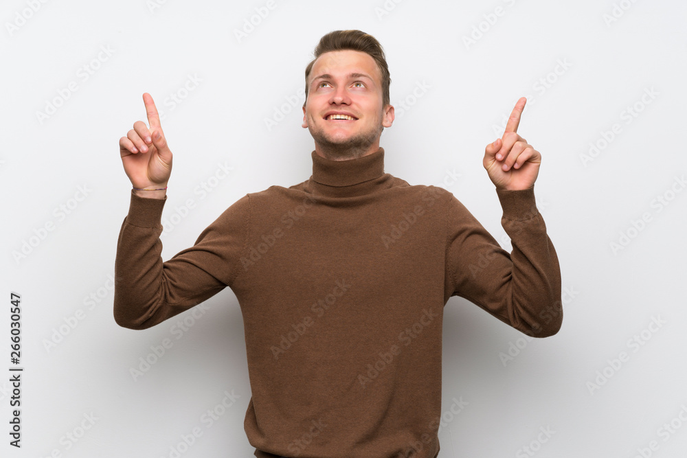 Blonde man over isolated white wall pointing with the index finger a great idea Blonde man over isolated white wall pointing with the index finger a great idea