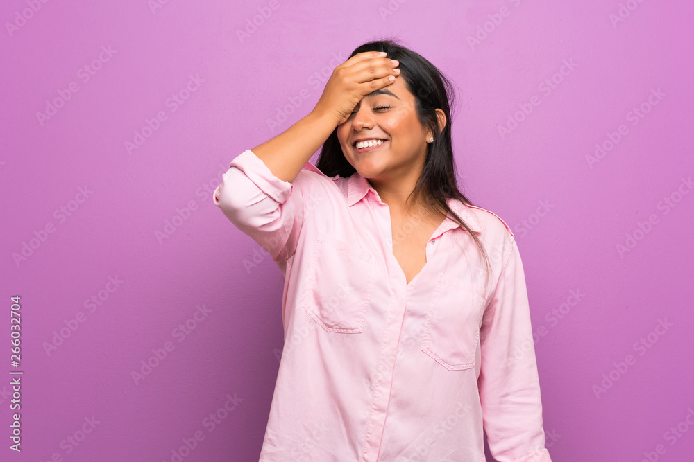 Young Colombian girl over purple wall has realized something and intending the solution