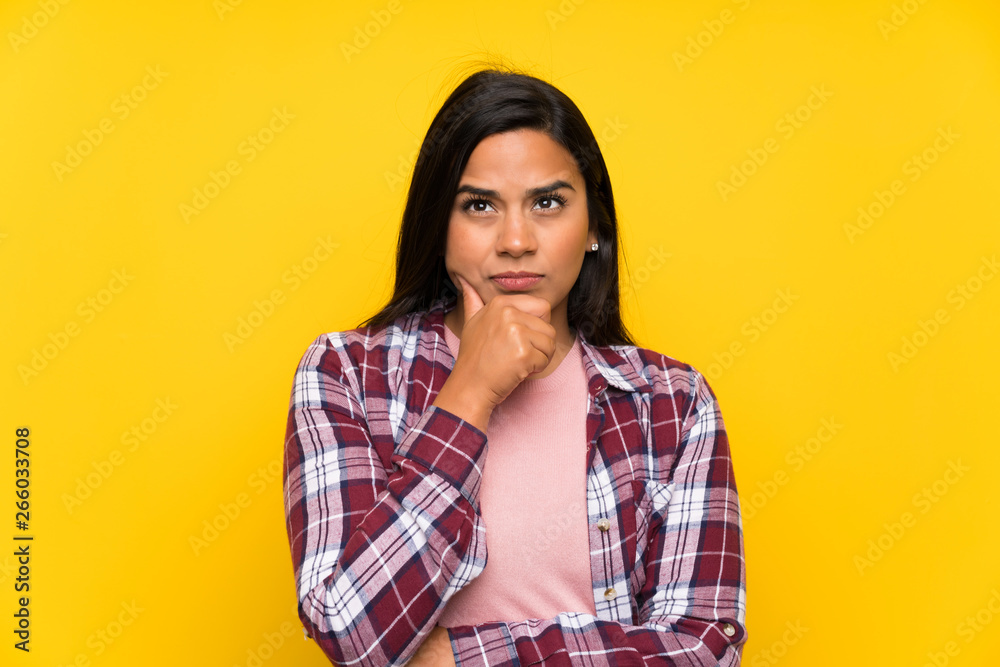 Young Colombian girl over yellow wall portrait Young Colombian girl over yellow wall portrait