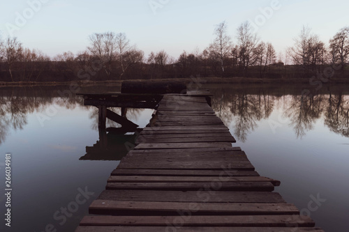 old wooden pier at small beautiful pond on sunset