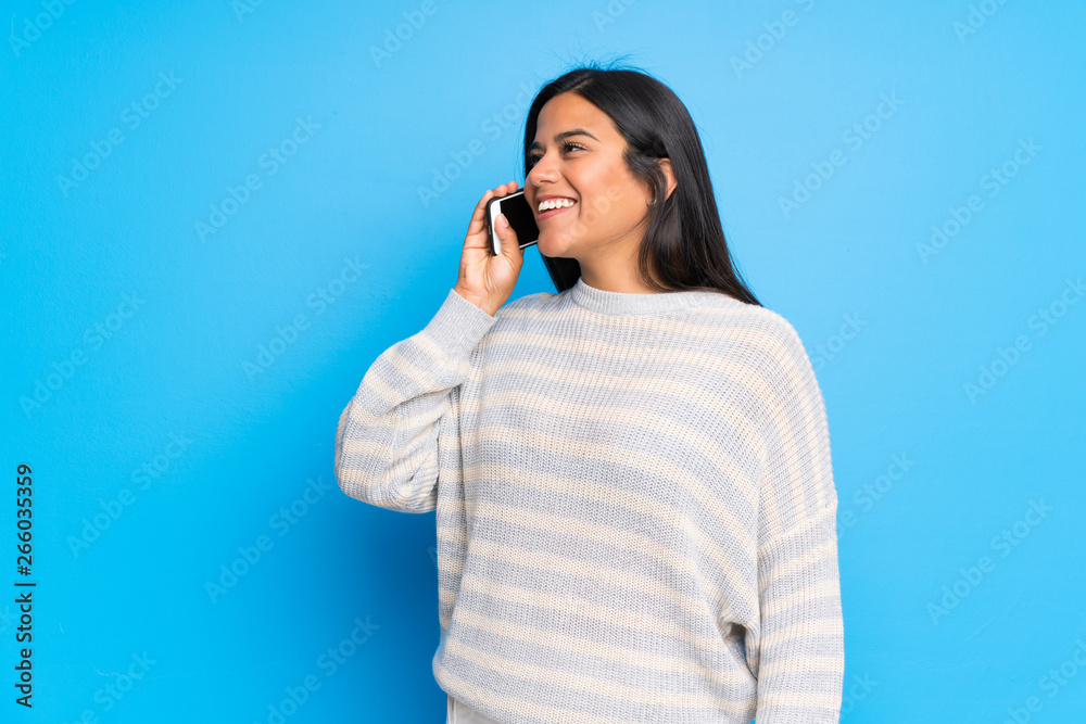 Young Colombian girl with sweater keeping a conversation with the mobile phone Young Colombian girl with sweater keeping a conversation with the mobile phone