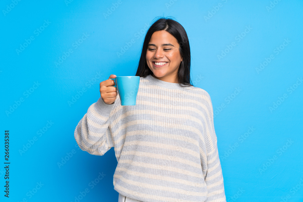 Young Colombian girl with sweater holding a hot cup of coffee Young Colombian girl with sweater holding a hot cup of coffee
