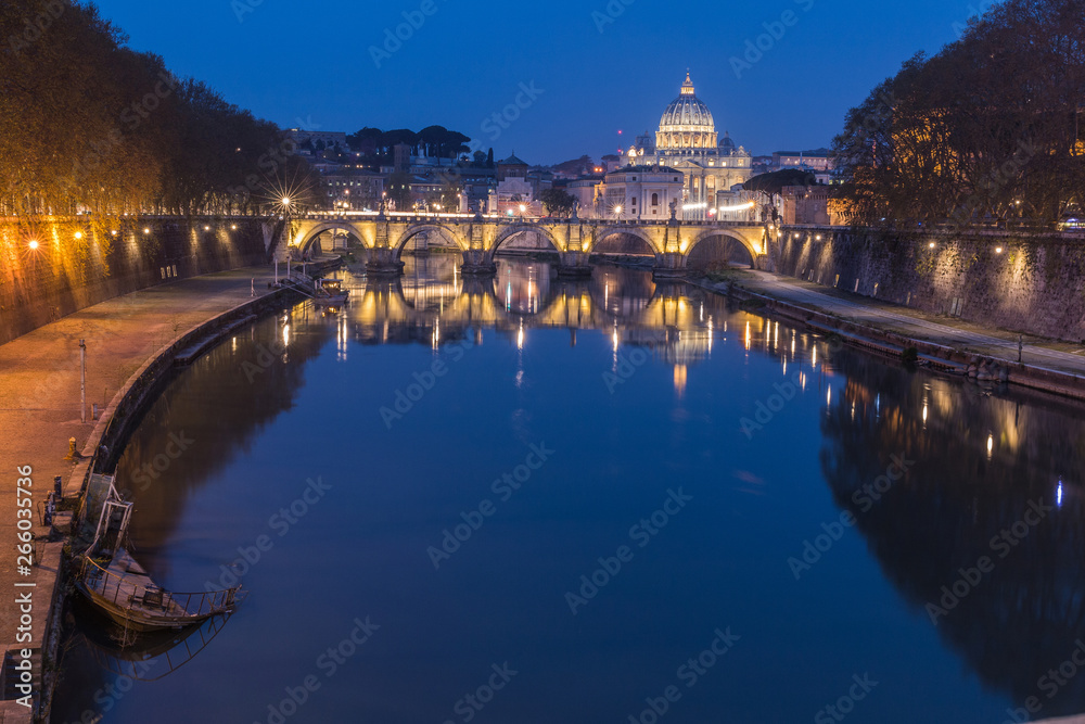 Tiber and St Peters Basilica with Aurelius Bridge or Ponte Sisto bridge at blue hour with a sunken boat on the shore with lighting. Stone bridge over river Tiber in the historic center of Rome