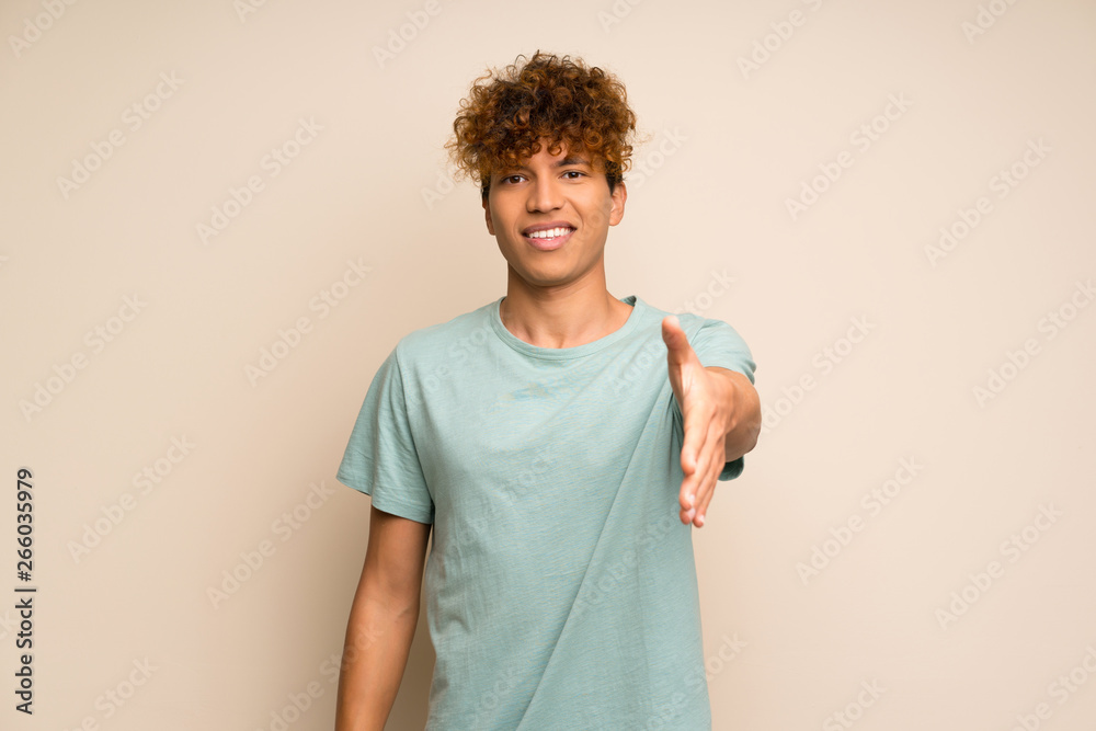 African american man with green shirt shaking hands for closing a good deal