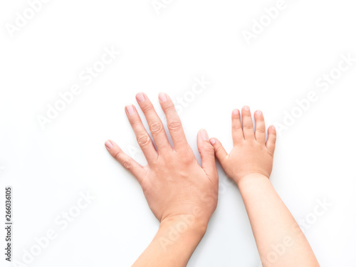 Hands of adult and child. Mother and kid put their palms together on white background. Parent and toddler. Symbol of family, unanimity, support. © Konstantin Aksenov