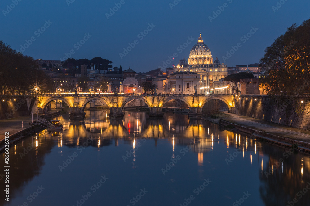 Tiber and St Peters Basilica with Aurelius Bridge or Ponte Sisto Bridge at the blue hour with lighting and reflections. Stone bridge at night over river Tiber in the historic center of Rome