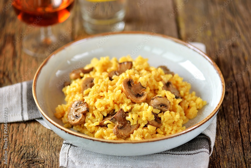 Traditional Italian risotto with mushrooms, saffron, parmesan cheese, vegetable broth and white wine. Top view. Copy space. Traditional Italian risotto with mushrooms, saffron, parmesan cheese, vegetable broth and white wine. Top view. Copy space.