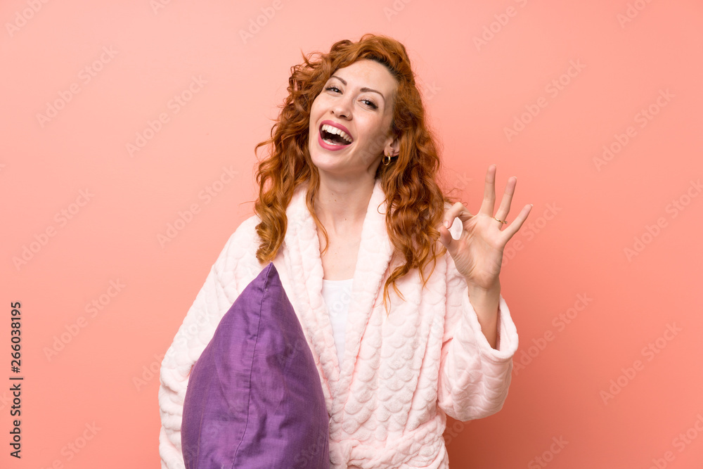 Redhead woman in dressing gown showing an ok sign with fingers Redhead woman in dressing gown showing an ok sign with fingers