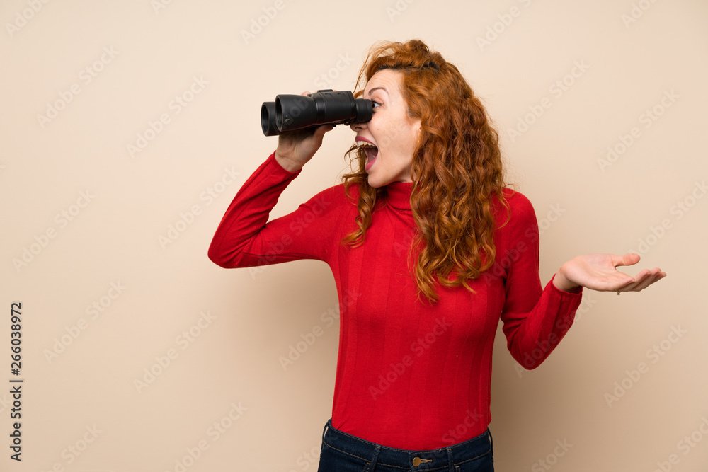 Redhead woman with turtleneck sweater with black binoculars Redhead woman with turtleneck sweater with black binoculars