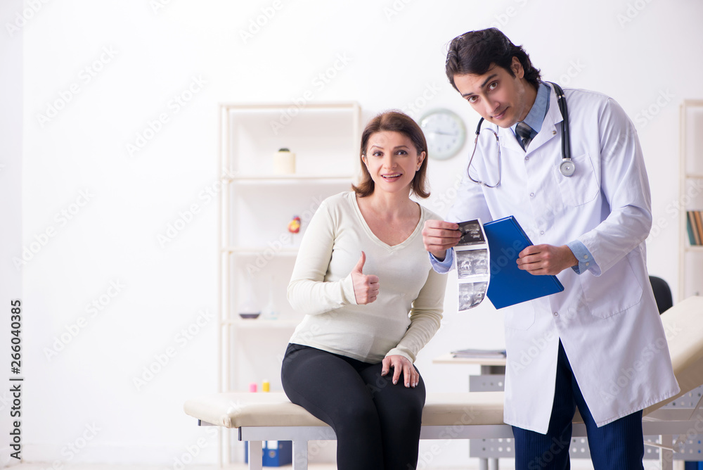 Fototapeta premium Old pregnant woman visiting young male doctor 