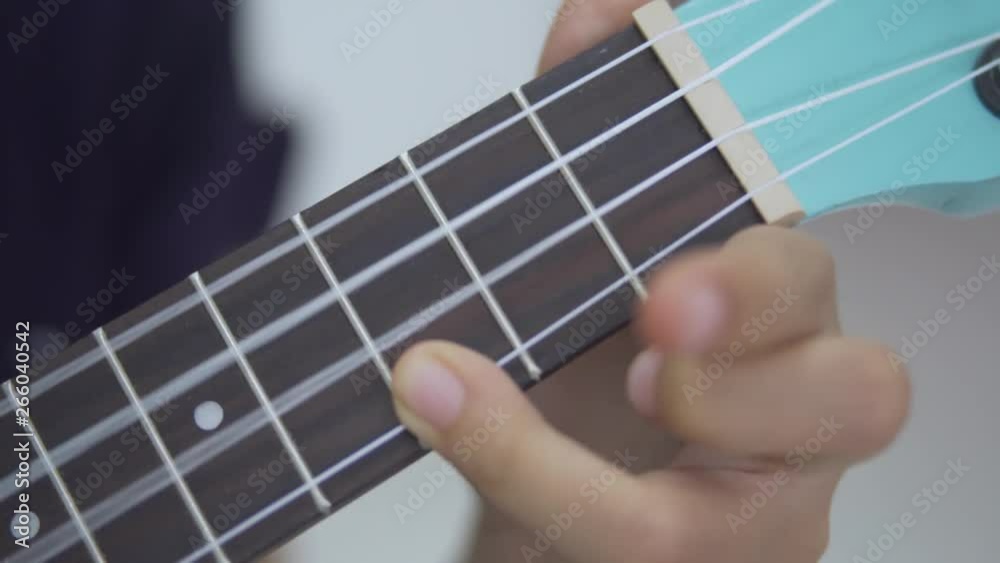 Closeup of little girl fingers playing guitar at home. Shot in 4k resolution Closeup of little girl fingers playing guitar at home. Shot in 4k resolution