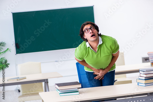 Male student suffering from urge in the classroom  