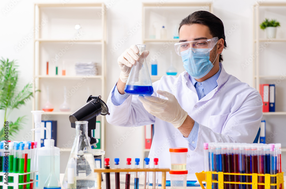 Young male chemist working in the lab 