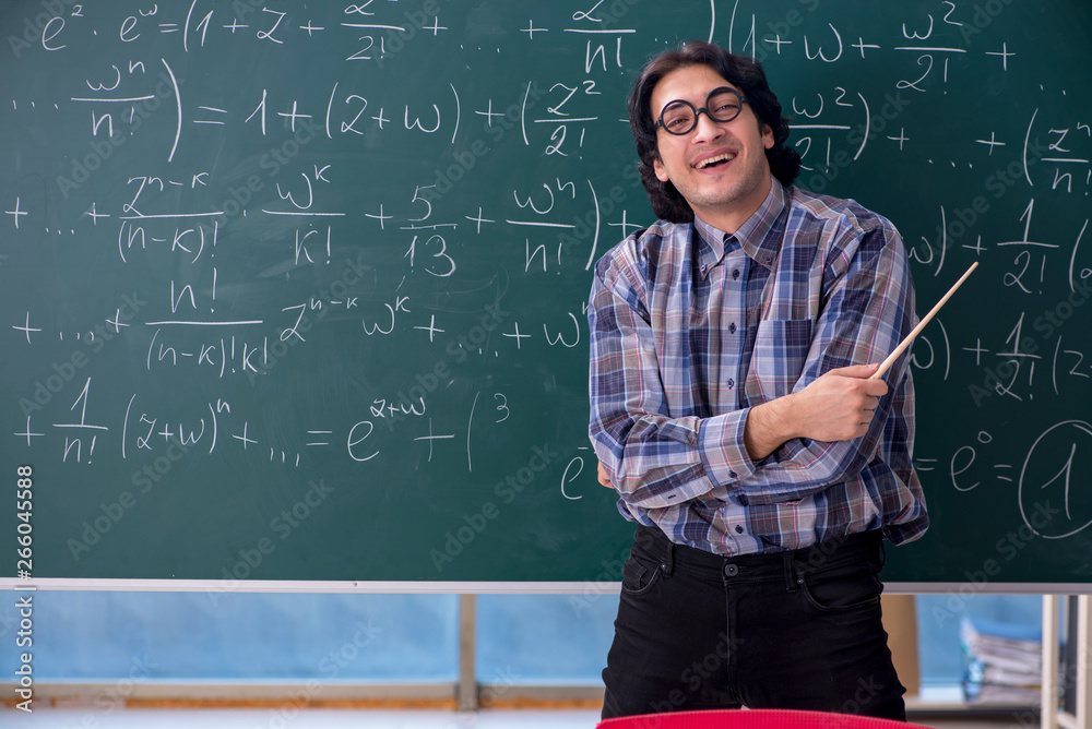 Young funny math teacher in front of chalkboard Young funny math teacher in front of chalkboard