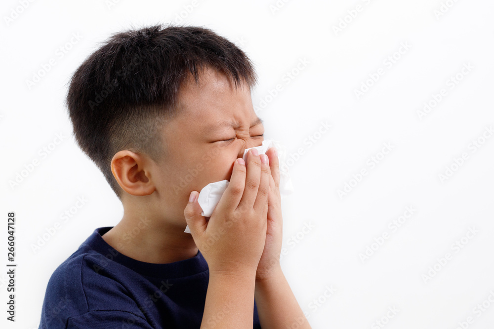 Sick little Asian boy using paper tissues while sneezing. Sick little Asian boy using paper tissues while sneezing.