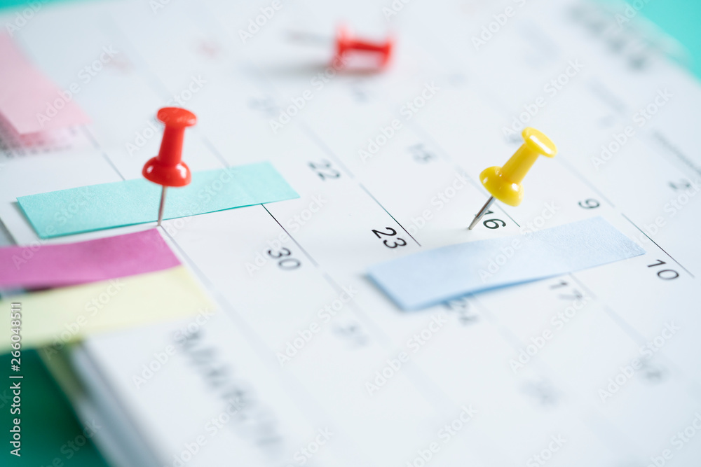 Fototapeta premium close up of pin on calendar, planning for business meeting or travel planning concept