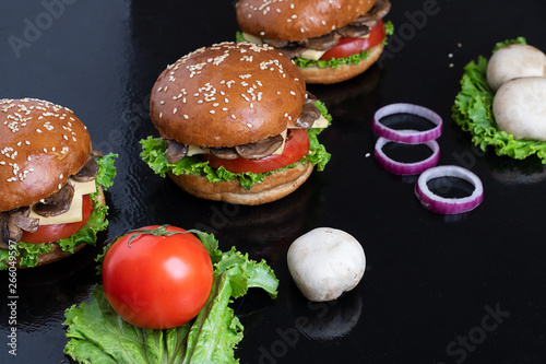 hamburger buns woth sesame on dark table, raw vegetables, homemade food