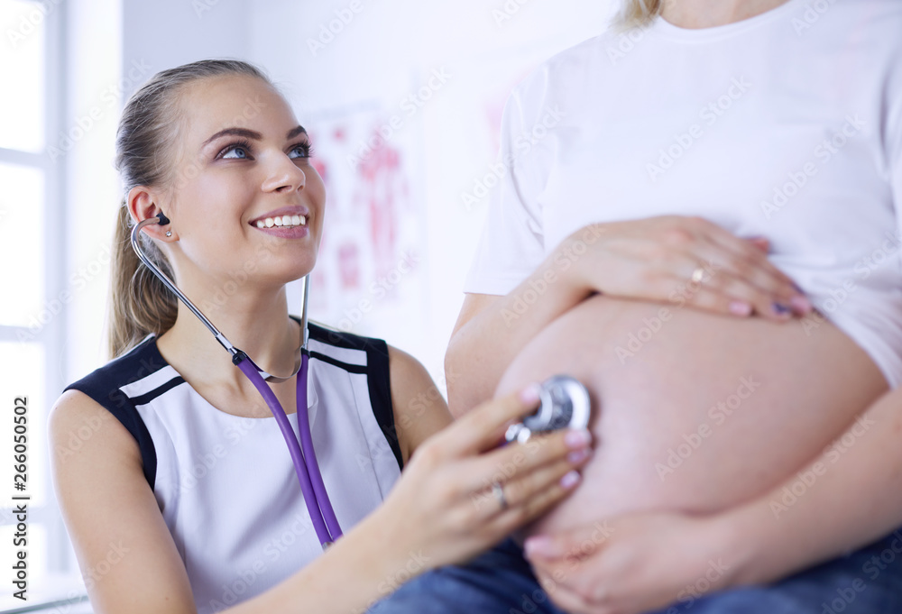 Young female doctor examining pregnant woman at the clinic. Young female doctor examining pregnant woman at the clinic.