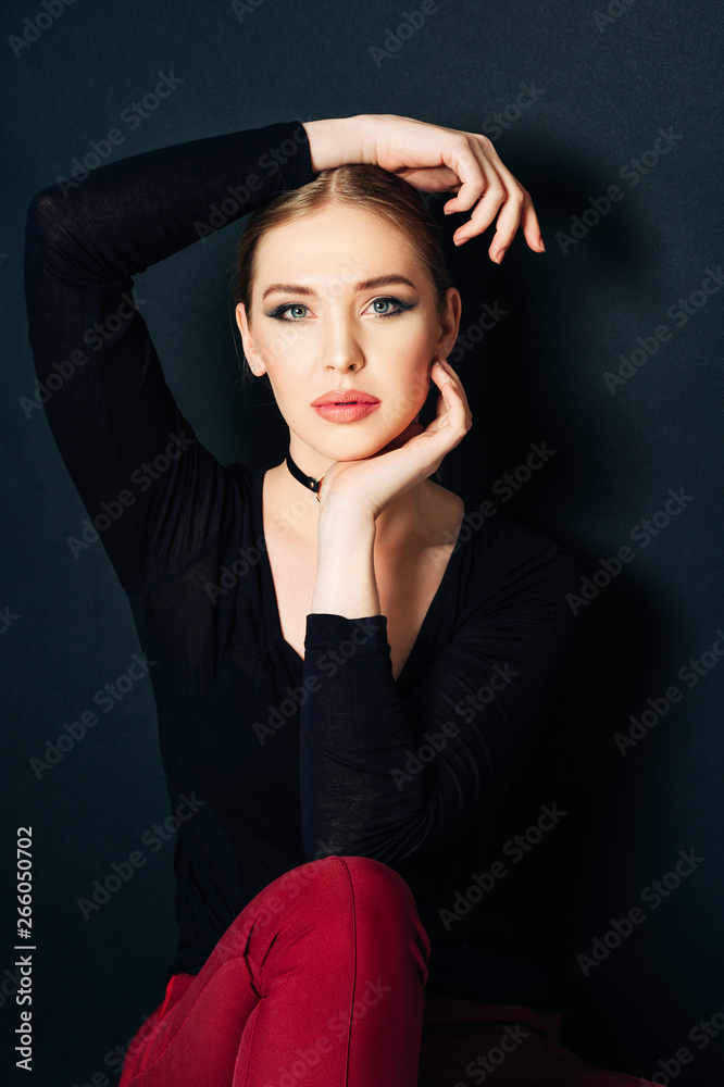Fashion portrait of beautiful young woman with dark professional make up, posing on black background Fashion portrait of beautiful young woman with dark professional make up, posing on black background