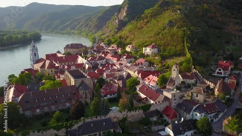 Aerial circling and fly over view of medieval Durnstein castle ruin and town in Wachau valley Lower Austria along the river Danube