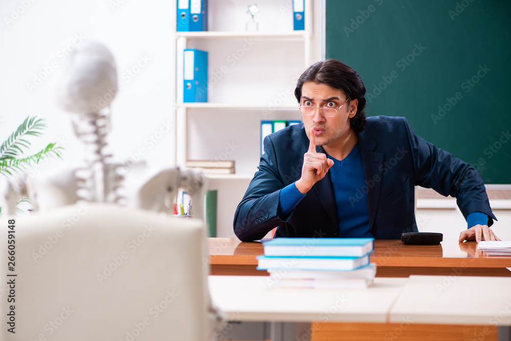 Male teacher and skeleton student in the classroom 