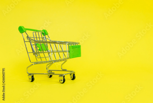 Shopping cart in the supermarket on a yellow background
