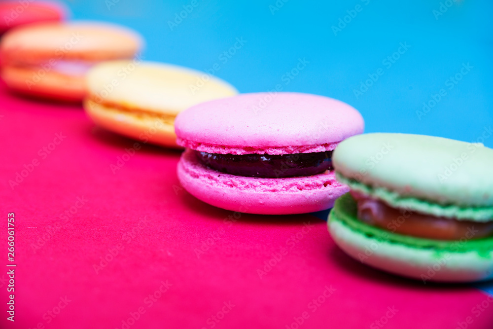 Fototapeta premium Tasty different colored macarons on multicolored background