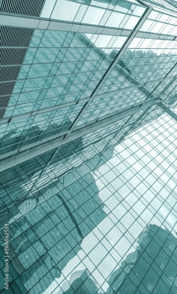 glass facade of a modern skyscraper. reflections of neighboring buildings.