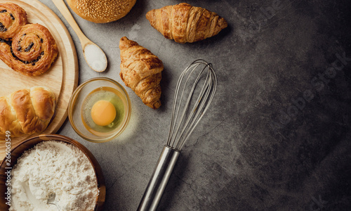 Freshly baked bread on wooden table,Bakery Concept- gold rustic crusty loaves of bread and buns on black chalkboard background. captured from above (top view, flat lay. Layout with copy space