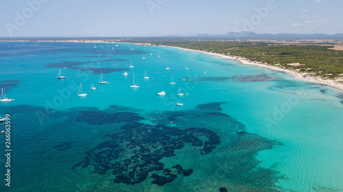 Amazing drone aerial landscape of the charming beach Es Trencs and the boats with a turquoise sea. It has earned the reputation of Caribbean beach of Mallorca. Spain © Matteo Ceruti
