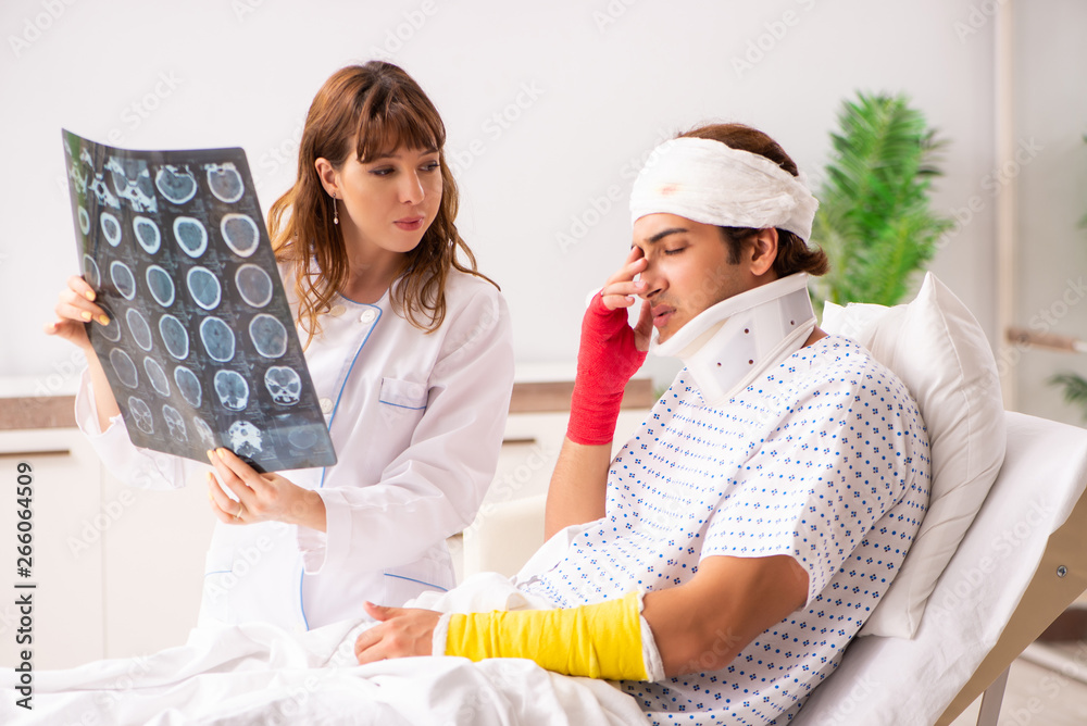 Obraz premium Young doctor examining injured patient 