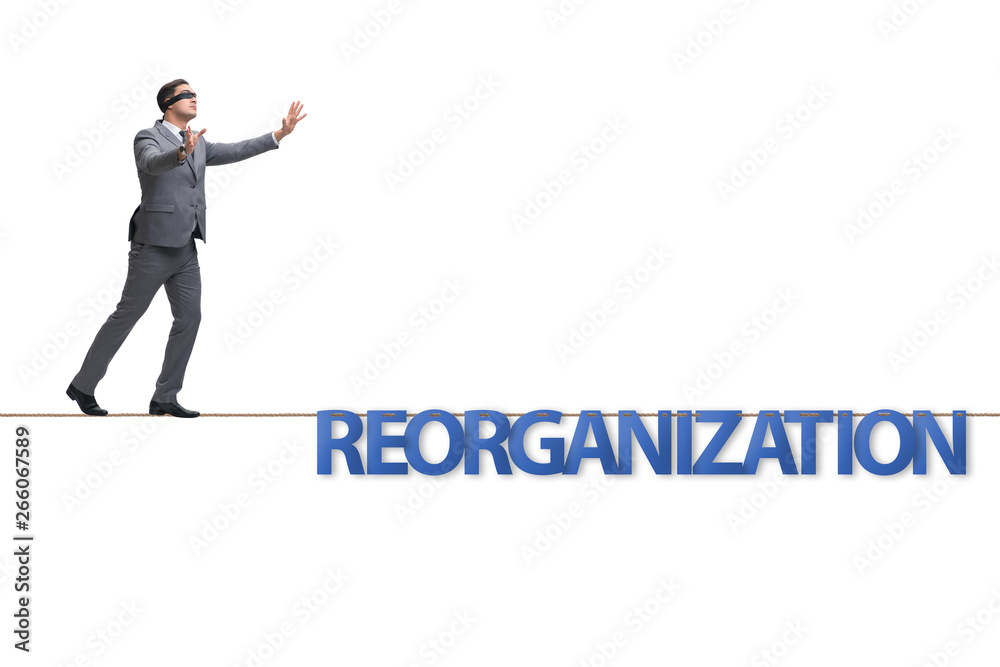 Reorganisation concept with businessman walking on tight rope Reorganisation concept with businessman walking on tight rope