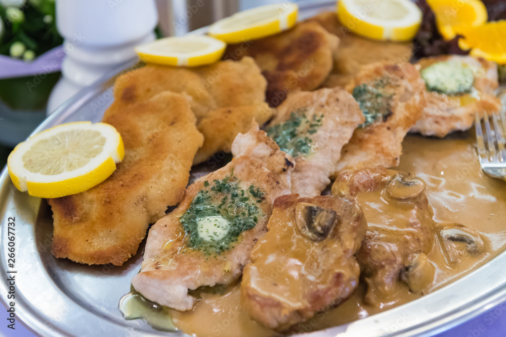 Schnitzelplatte mit Zitronenscheiben und Kräuterbutter Schnitzelplatte mit Zitronenscheiben und Kräuterbutter
