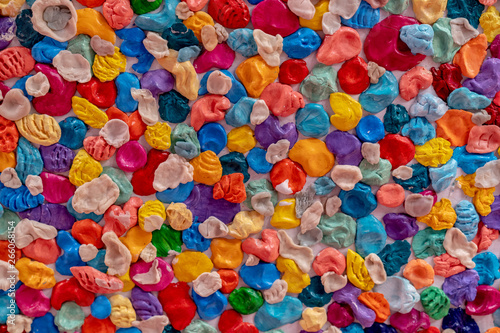 A lot of multi-colored chewing gums pasted on the wall creates a uniform texture.