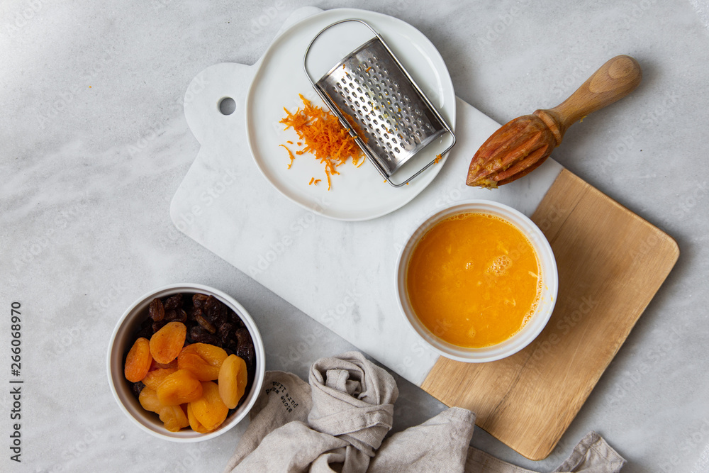 Fototapeta premium Fresh Orange Juice and Peel, raisins, dried apricots, almonds on marble backround with copy space