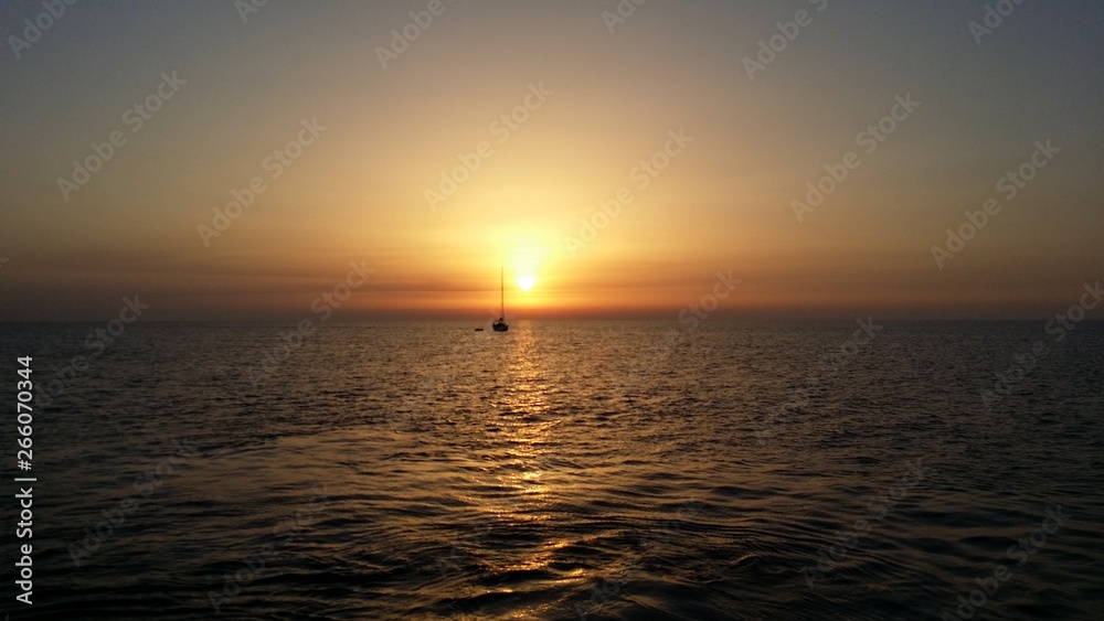 tramonto sul mare con barche